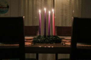 Photo of lit Advent candles in a dimly lit dining room.